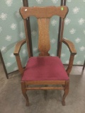 Vintage tiger oak chair with red upholstered seat.
