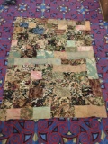 Vintage hand made quilt feat. various floral patterns, and checkered with many fabrics