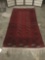 Long red handwoven wool rug w/stunning geometric patterns & fringe. Approx. 94x42 inches.