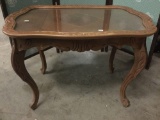 Antique tea table with wood inlay and removable glass top serving tray, approx 28x19x20 inches.