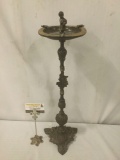 Antique metal ashtray w/stately base & child statue in center of tray. Approx. 7x7x25 inches.