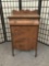 Antique cabinet with drawer, burled finish and carved accents