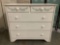 Mako Wood Products 5-drawer dresser painted white with floral detail, approx 18 x 39 x 34 inches.