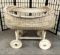 Vintage wicker and wood painted baby bassinet on wheels. Approx 36x34x32 inches.