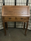 Wooden two-drawer secretaries desk w/cabriole legs, approx. 33x17x42 inches.