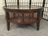 Modern round glass top wood coffee table with lipped edge. Approx 36x36x18 inches.