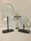 Pair of Global Bazaar magnifying glasses on stands, largest approx. 13.5x6x4 inches.