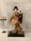 2018 Japanese female doll holding a plum blossom in glass display box, approx. 7.5x6.5x14.5 inches.