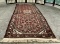 Red wool carpet w/ fringe & floral designs, approx. 62x30 inches.