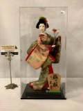2018 Japanese female doll holding a plum blossom in glass display box, approx. 7.5x6.5x14.5 inches.