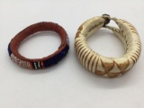 Pair of vintage leather African bracelets. One is beaded. Largest approx 3.5x3x1 inches.