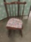 Vintage rocking chair with floral seat cushion.