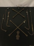 Eight vintage metal items: crowbars, tire irons, & tow hitch. Approx. 20x20x1 inches.