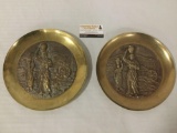 Pair of Mid-Century Brass character plates depicting woman working at a mill.