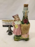 Vintage porcelain olive oil bottle w/ young girl in pink dress, approx. 4x7 inches.