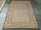 Earth tone rug w/ floral designs, approx. 90x63 inches.