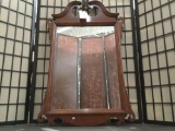 Wood frame wall mirror w/ regal detailing, approx 45 x 26 inches.