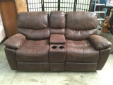Brown leather style reclining loveseat w/ center console & 2 cup holders