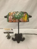 Metal base turtle desk lamp with stained glass style shade, some colors peeling off.