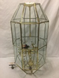 Hanging chandelier light fixture with glass shade, one pane missing.