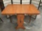 Antique oak turn of the century drop leaf kitchen table with single drawer and wheat design