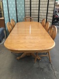 Vintage long oak dining table with 6 chairs, 2 leaves and footed trestle base