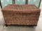 Modern woven wicker storage trunk, shows wear, approximately 30 x 18 x 19 inches.
