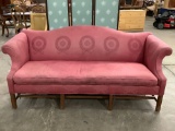 Vintage couch w/ red upholstery & regal design, shows wear, sold as is.