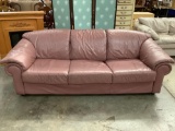 Mauve vinyl couch in good condition, approx. 87 x 36 x 31 inches.