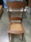 Vintage wood carved chair with woven wicker seat, approximately 20 x 41 x 19 in.