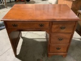 Vintage wood desk w/ 4 drawers, shows finish wear/scratches, approx 38 x 24 x 30 in.