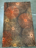 Small area rug, orange / brown w/ spiral spoke design, approximately 43 x 68 in.