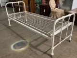 Antique metal single bed frame on wheels, approx. 31 x 78 x 33 in.