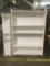 Large real word white bookshelf with adjustable shelves and small knickknack storage shelf