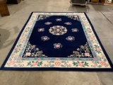 Large wool carpet w/ pink floral design, deep blue background, approx 108 x 142 in. Nice condition