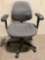 Rolling office chair with gray upholstered seat and back, sold as is.