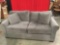 Like new very attractive gray upholstered loveseat hide a bed