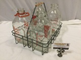 Vintage lot of 4 glass milk bottles plus wire carry rack, approx 13 x 11 x 11 in.