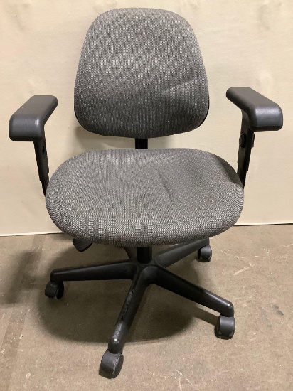 Rolling office chair with gray upholstered seat and back, sold as is.