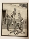 Framed antique B&W photo of girls on bikes, approx 14 x 17 in.