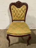 Antique wood carved chair w/ upholstery/ 2 wheels, face carving, approx 19 x 18 x 36 in.