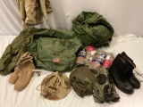 US military canvas bags stuffed full of camouflage uniform pieces, flight suit, gas mask, briefs in