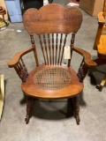 Vintage wooden rocker with cane seating and turned spindles