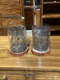 Pair of glass candleholders with wooden bases and metal leaf designed inserts