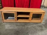 Wood entertainment center with shelves and glass doors that convert into speaker cabinets
