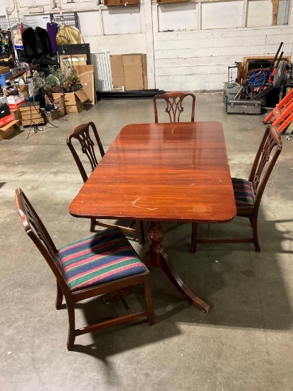 Solid wood rectangular dining table with leaf and 4 matching chairs.
