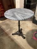 Beautiful beveled stone top circular table with cast iron base.