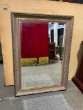 ANTIQUE beveled MIRROR WITH INTRICATE DESIGNS on frame.