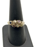 14k gold women's ring featuring a variety of small gem stones, opal, ruby, pearl , amethyst etc..