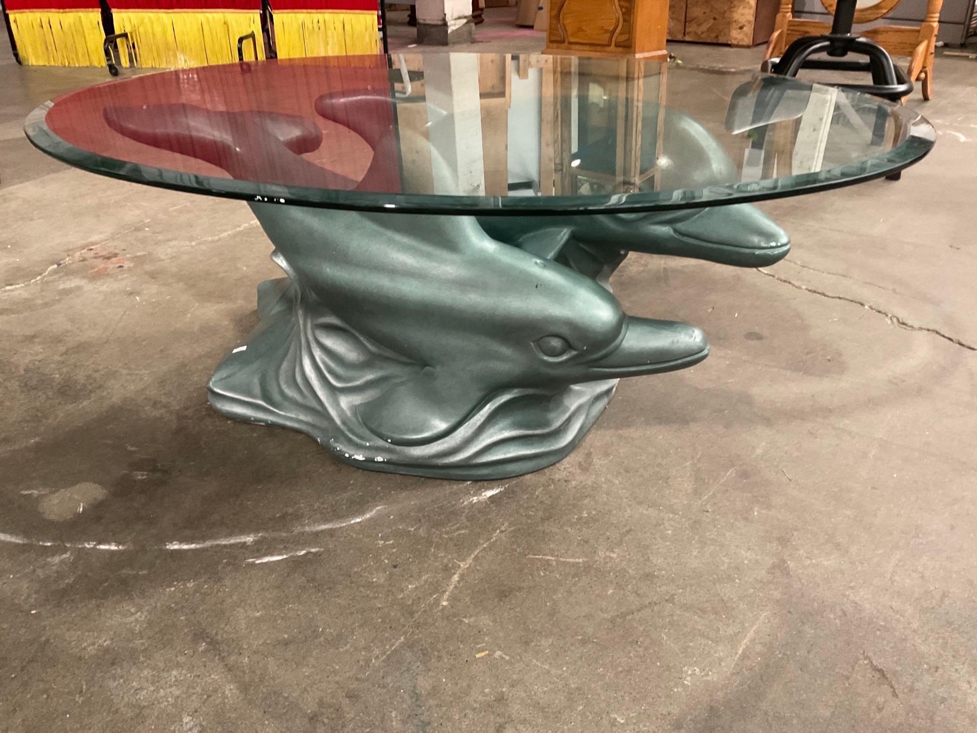Glass table with dolphins as base and glass top. Proxibid